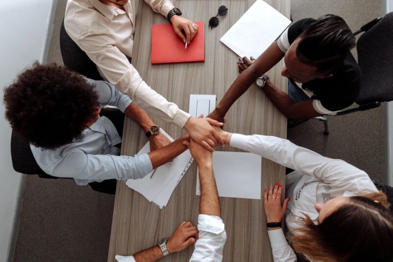 Een groep professionele werknemers die samenwerken in een kantoor, symboliserend employer branding en teamgeest.
