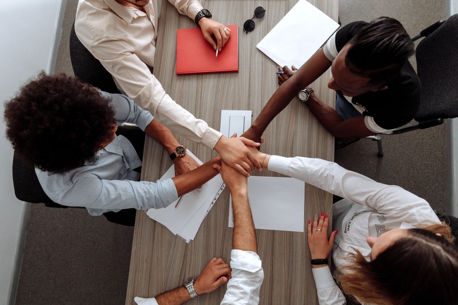 Een groep professionele werknemers die samenwerken in een kantoor, symboliserend employer branding en teamgeest.